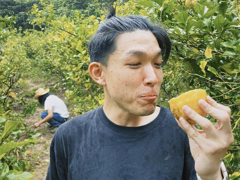 畑で採れたレモンを味見する男性